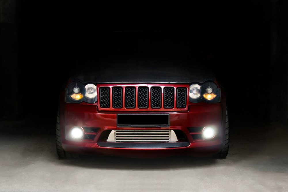 grand cherokee in the shadow front view with headlights on