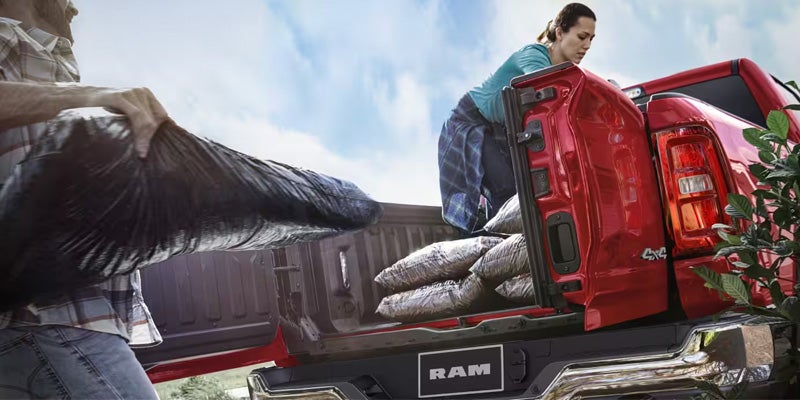 Ram 1500 pickup truck with family loading cargo in truck bed